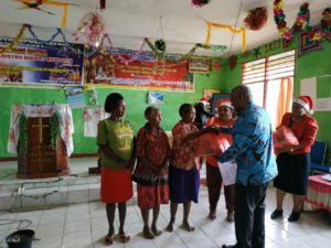 Gubernur Papua Barat, Drs Dominggus Mandacan menyerahkan bingkisan Natal secara simbolis kepada 100 ibu janda pada saat perayaan natal Ikatan Perempuan Arfak Papua Barat di GPKAI Laharoi Demaisi, Pegaf, Sabtu (8/12/2018)