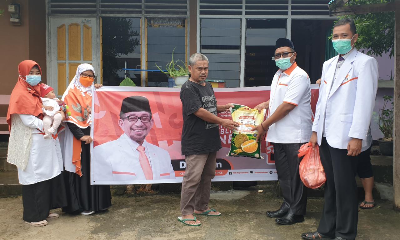 H. Muhammad Taslim saat membagikan Paket Sembako kepada perwakilan salah satu warga di Jembatan Puri. [foto: humas pks]